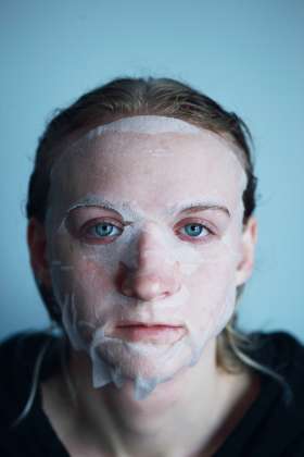 girl with blue eyes and white facial mask and chemical peel for acne scars