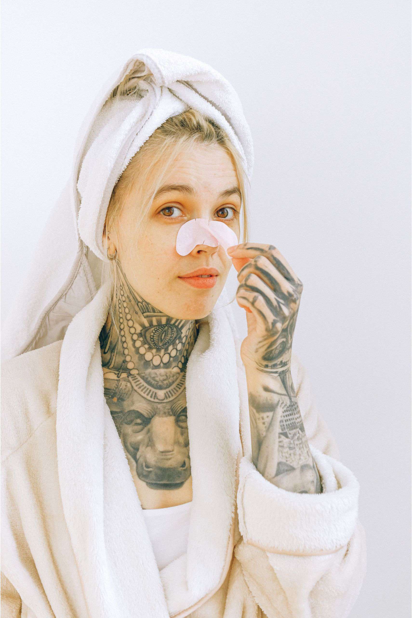 woman with tattoos and nose pore strip