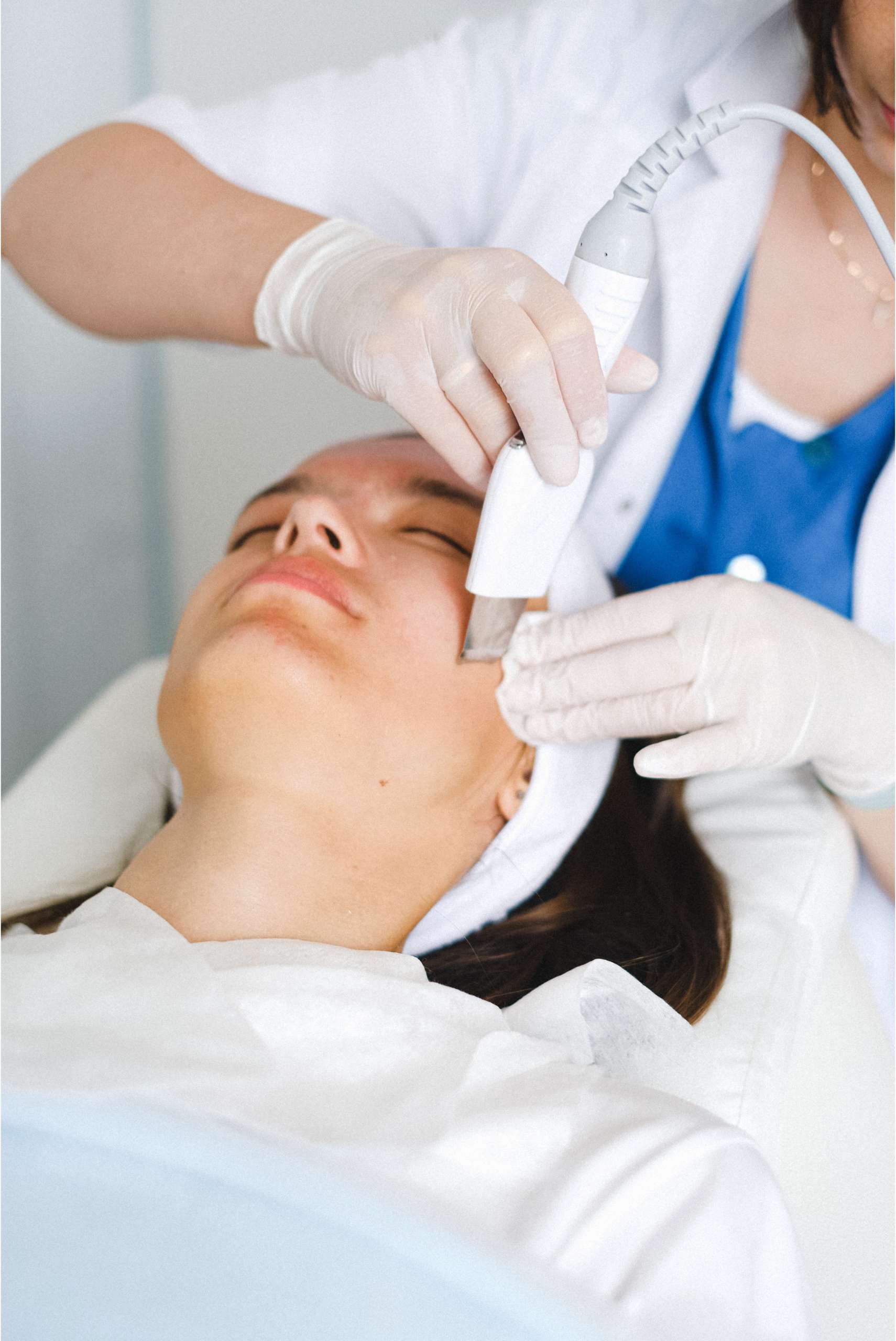 woman undergoing facial procedure in dermatologist clinic